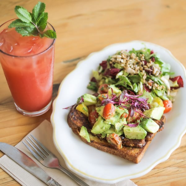 Kitchen Mouse avocado toast with cherry tomatoes and microgreens, side salad, and pink drink.